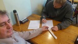 Kapitáni a rozhodčí tvoří zápis v deset dopoledne. Vlevo kapitán hostů R. Vavřínek, uprostřed teploměr, vpravo domácí kapitán v roli rozhodčího S. Jaššo